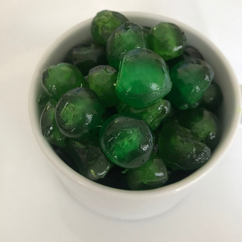 A bowl of whole glazed green cherries 