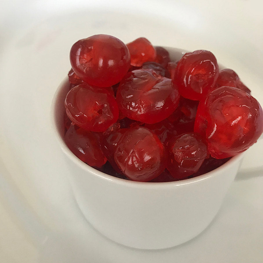 A bowl of whole glazed red cherries 